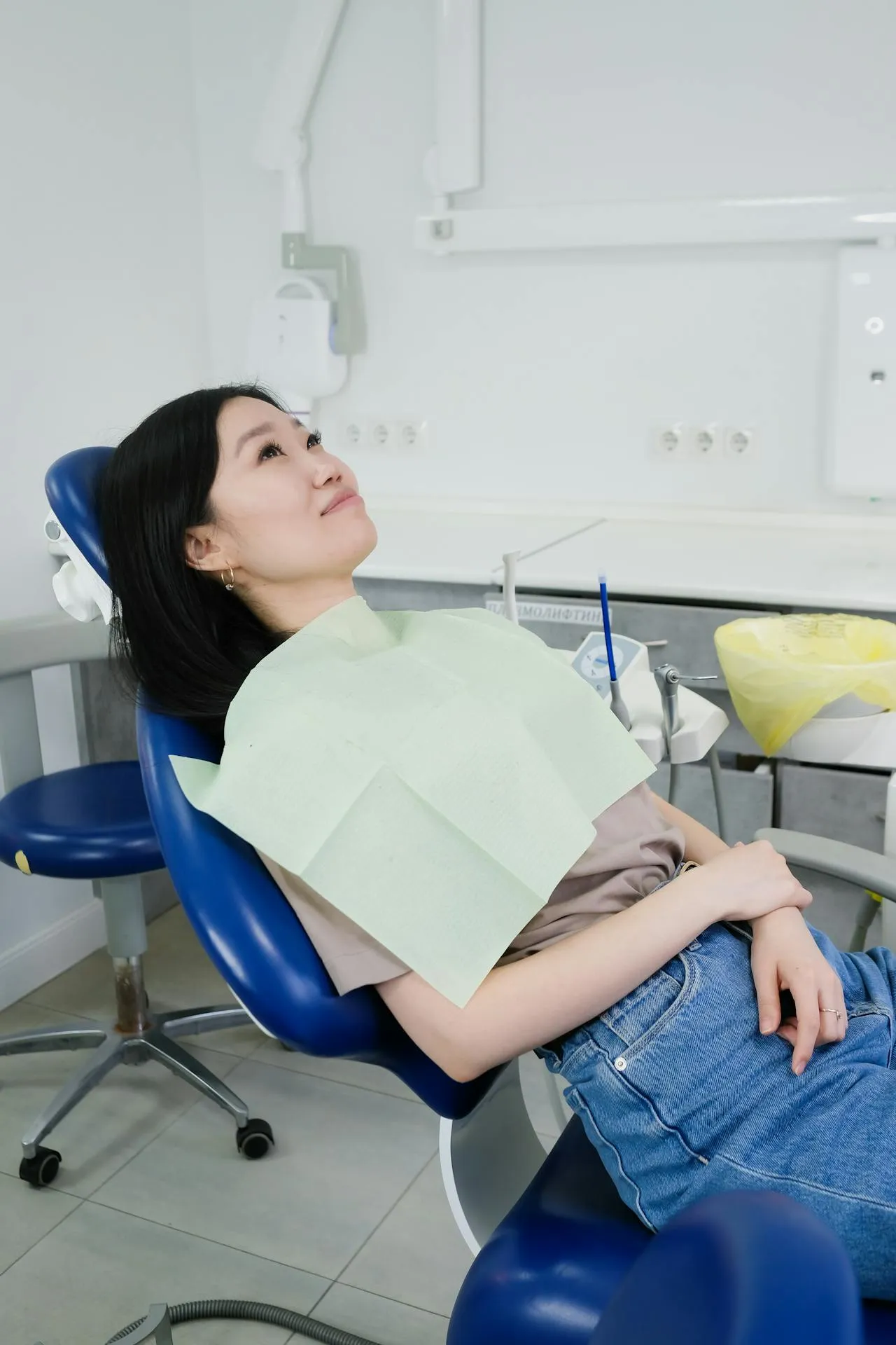 A female patient relaxing and smiling in a dental chair after completing her dental treatment at a top Turkish clinic in Antalya — real results from real patients